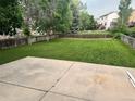 Large, grassy backyard enclosed by a wooden fence with a concrete patio at 21767 Silver Meadow Ln, Parker, CO 80138