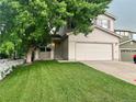 Traditional two-story home featuring a well-maintained lawn and a large shade tree at 21767 Silver Meadow Ln, Parker, CO 80138