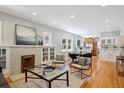 Open-concept living area with fireplace, seamlessly connecting to the dining space and kitchen at 2683 Bellaire St, Denver, CO 80207