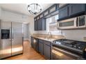 Well-appointed kitchen with stainless steel appliances, dark cabinetry, and hardwood floors at 2921 N Fillmore St, Denver, CO 80205