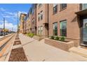 Brick townhomes line the street, with landscaped entrances and modern architecture, reflecting urban living at 2436 Welton St, Denver, CO 80205