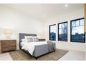 Bright bedroom features three large windows, light wood floors, and neutral decor at 1110 Elm St, Denver, CO 80220