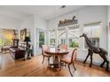 Dining room with wood floors, natural light, decorative giraffe statue, and seating for four at 7611 S Addison Way, Aurora, CO 80016
