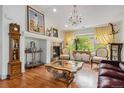 Living room with fireplace, hardwood floors, decorative chandelier, and bright view of outdoors at 7611 S Addison Way, Aurora, CO 80016