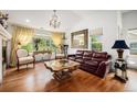 Elegant living room features hardwood floors, a decorative chandelier, and large windows with a great view at 7611 S Addison Way, Aurora, CO 80016