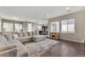 Open-concept living area with a comfortable sectional sofa, hardwood floors, and bright windows at 9628 Dunning Cir, Highlands Ranch, CO 80126