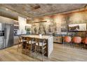 Open kitchen with concrete ceiling, brick wall, light wood floors, large island and seating at 1801 Wynkoop St # 401, Denver, CO 80202