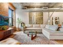 Bright living room with concrete ceiling, brick wall, light wood floors, and comfortable sofa at 1801 Wynkoop St # 401, Denver, CO 80202