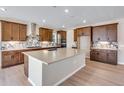 Spacious kitchen boasts a large island, stainless steel appliances, stylish backsplash, and wooden floors at 3422 N Gold Bug Ct, Aurora, CO 80019