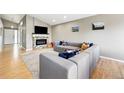 Bright living room boasts a modern fireplace, sleek TV, and comfortable gray sectional sofa at 3715 E 139Th Pl, Thornton, CO 80602