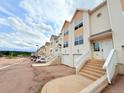 Exterior view of townhomes with attached garages, and stairways leading to front entryways at 94 Vale St, Palmer Lake, CO 80133