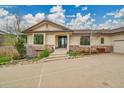 An inviting home featuring stone accents, a tile roof, an elegant front door, and a well-maintained front yard at 5688 Red Fern Ct, Littleton, CO 80125