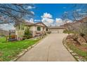 A luxurious home boasts a three-car garage and a well-manicured lawn complemented by elegant stone accents along the facade at 5688 Red Fern Ct, Littleton, CO 80125