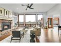 Bright living room featuring a stone fireplace, hardwood floors, and large windows with views of red rock formations at 5688 Red Fern Ct, Littleton, CO 80125