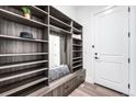 Well-organized mudroom with custom shelving, seating, and a convenient mirror at 16262 W 95Th Ln, Arvada, CO 80007