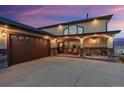 Exterior view of a home featuring an attached garage and front patio with seating at 16101 Iola St, Brighton, CO 80602
