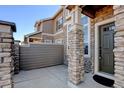 Inviting entryway with stone pillar and gated front patio at 4742 Raven Run, Broomfield, CO 80023