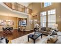 Open living area with high ceilings, hardwood floors, and view of kitchen and second floor at 4742 Raven Run, Broomfield, CO 80023