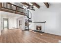 Spacious living room boasts a cozy fireplace, exposed beams, and spiral staircase leading to a loft at 11820 Lincoln St, Northglenn, CO 80233