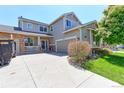 Two-story home featuring a manicured lawn, covered porch, and an attached two-car garage at 9994 Quintero St, Commerce City, CO 80022