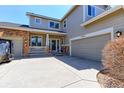 Home featuring a manicured lawn, covered porch, and an attached two-car garage at 9994 Quintero St, Commerce City, CO 80022