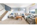 Cozy living room with plush carpet, a large sectional sofa, and a stylish accent wall at 11455 W 17Th Pl, Lakewood, CO 80215