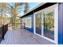 Home deck area with wood flooring and a sliding glass door entrance to the interior at 4642 Plettner Ln, Evergreen, CO 80439