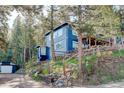 Exterior elevation of the blue home featuring a well-manicured, natural landscape at 4642 Plettner Ln, Evergreen, CO 80439