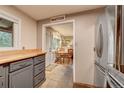 Charming kitchen view through to the dining area, stainless steel refrigerator and gray cabinets at 4642 Plettner Ln, Evergreen, CO 80439