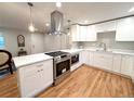 Modern kitchen with stainless appliances, quartz counters, new cabinets, and hardwood floors at 10253 W 68Th Way, Arvada, CO 80004