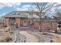 Charming brick home with a landscaped walkway leading to the entrance, mature trees, and great curb appeal at 767 Ellis St, Golden, CO 80401