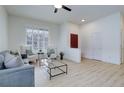 Bright living room featuring wood floors, high ceilings, and large windows for natural light at 16159 W 70Th Pl, Arvada, CO 80007