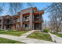 Modern townhouse with brick and wood accents, multiple balconies, and a well-manicured lawn at 3201 W 25Th Ave, Denver, CO 80211