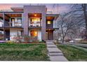 Modern townhouse with brick and wood accents, multiple balconies, and a well-manicured lawn at dusk at 3201 W 25Th Ave, Denver, CO 80211
