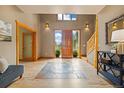 Grand foyer with natural wood accents, a custom tile inset, and large windows at 1140 Indian Peak Rd, Golden, CO 80403