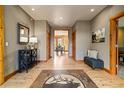 Inviting foyer with wood flooring, a custom tile inset, and a view into the dining area at 1140 Indian Peak Rd, Golden, CO 80403