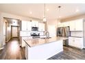 Bright kitchen featuring white cabinets, stainless steel appliances, and a large center island at 14758 Normande Dr, Mead, CO 80542