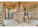 Charming front porch showcasing brick accents and outdoor seating for relaxation at 9816 Kalispell St, Commerce City, CO 80022