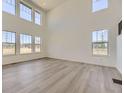 Bright and airy living room featuring high ceilings, large windows, and wood-look flooring at 2968 S Poppy St, Morrison, CO 80465