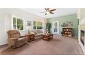 Cozy living room featuring large windows, a ceiling fan, comfortable seating, and natural light at 2239 Calais Dr # 11F, Longmont, CO 80504