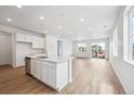 Open-concept kitchen with white cabinets, stainless steel appliances, and lots of natural light at 6616 N Nepal St, Aurora, CO 80019