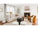 Cozy living room with fireplace, plush seating, and ample natural light at 1140 Devonshire Ct, Lafayette, CO 80026