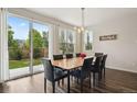 Bright dining room with modern lighting, a large window, and access to the backyard through sliding glass doors at 11151 W 53Rd Dr, Wheat Ridge, CO 80033