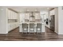 Spacious kitchen features white cabinets, stainless steel appliances and a large island with seating at 11151 W 53Rd Dr, Wheat Ridge, CO 80033