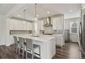 Bright kitchen features white cabinets, stainless steel appliances and a large island with seating at 11151 W 53Rd Dr, Wheat Ridge, CO 80033