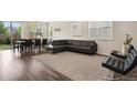 Open-concept living room with wood floors, a large leather sectional, and a view of the backyard at 11151 W 53Rd Dr, Wheat Ridge, CO 80033