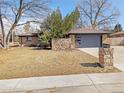 Ranch-style home with brick exterior, a two-car garage, and a stone mailbox in a sunny, grassy front yard at 328 Quay St, Lakewood, CO 80226