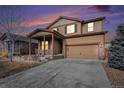 Inviting two-story home with a covered entry, two-car garage, and lovely stone and siding details at 1788 Taos St, Brighton, CO 80603