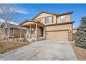 Inviting two-story home with a covered entry, two-car garage, and lovely stone and siding details at 1788 Taos St, Brighton, CO 80603