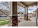 View from the front porch, showcasing stone-clad pillars and a glimpse of the neighborhood street at 2305 Prospect Ln, Broomfield, CO 80023